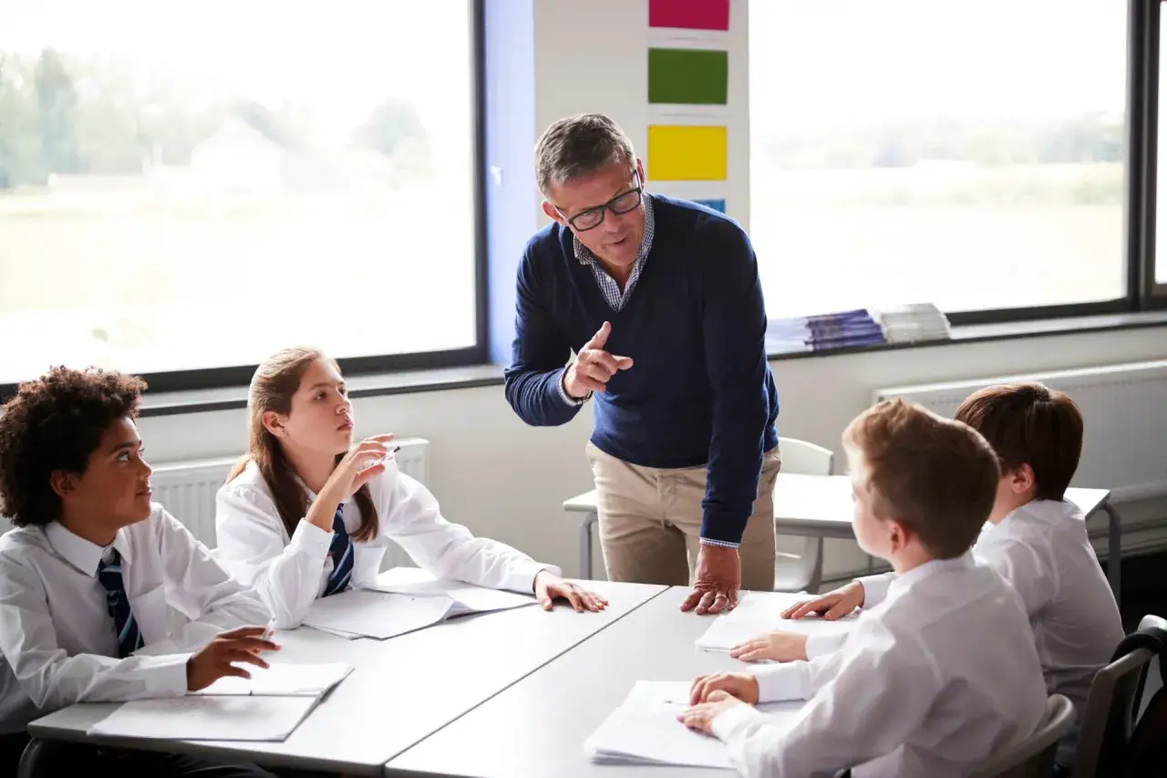 Lehrer erklärt eindringlich, ob er Schüler anschreien darf. Die Schüler hören aufmerksam zu.