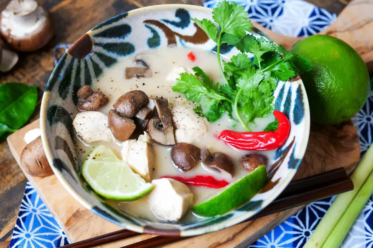 Authentische Zutaten für Tom Kha Gai Suppe auf einem Holztisch