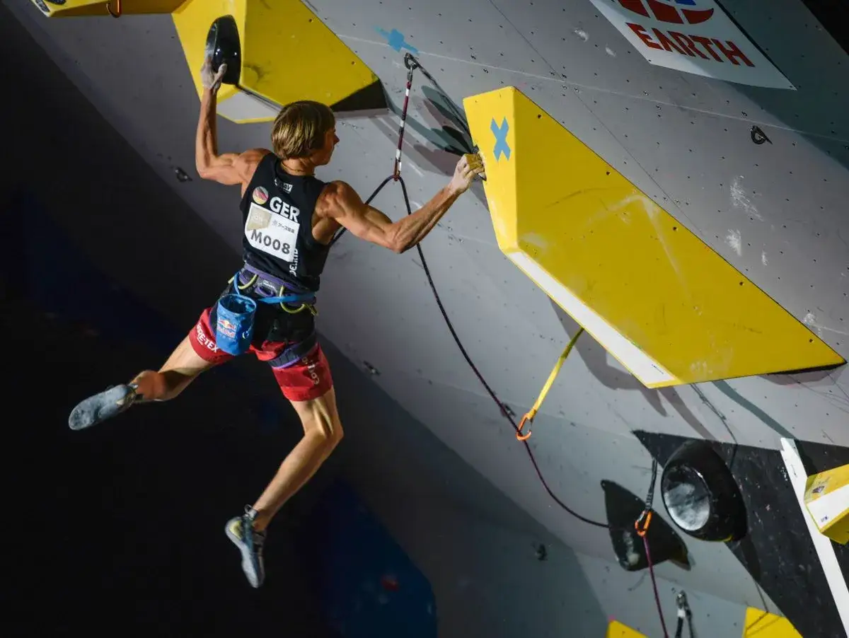 Alex Megos in Aktion an der Kletterwand, ein deutscher Athlet in voller Konzentration.