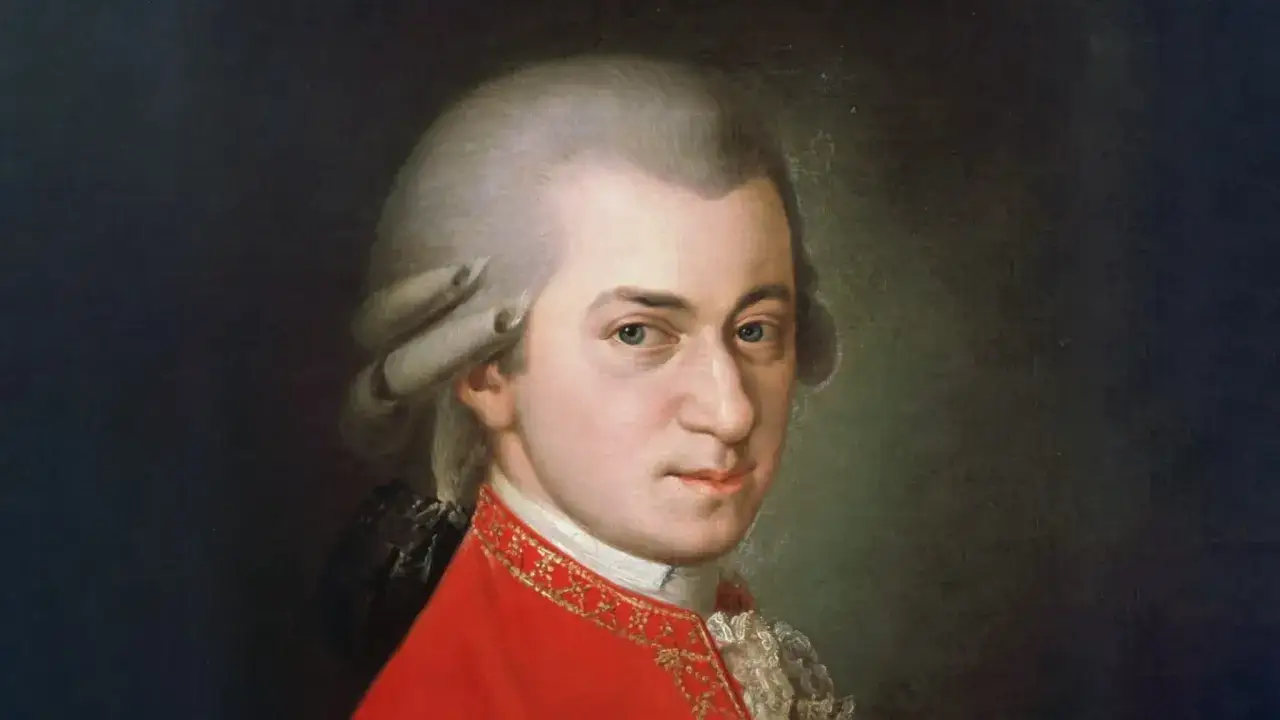 Portret Wolfganga Amadeusza Mozarta w czerwonym stroju z bogatymi zdobieniami.