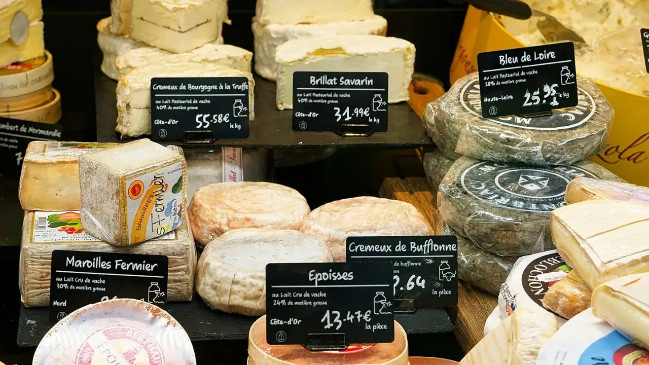 Assortimento di formaggi francesi, tra cui un delizioso formaggio di capra, in una vetrina.