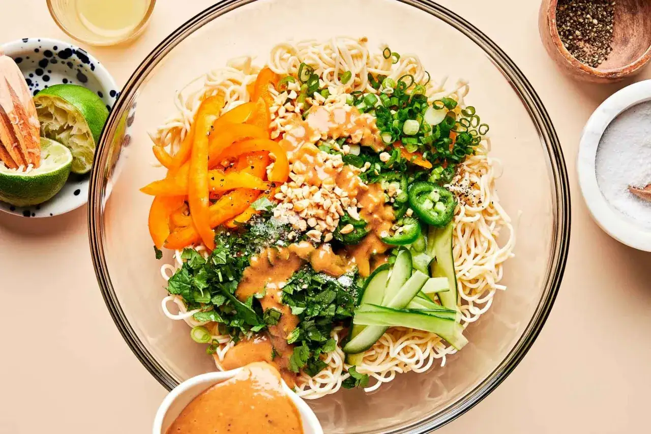 Bunter mie nudelsalat mit Erdnusssauce, Paprika, Gurke, Frühlingszwiebeln und Koriander.