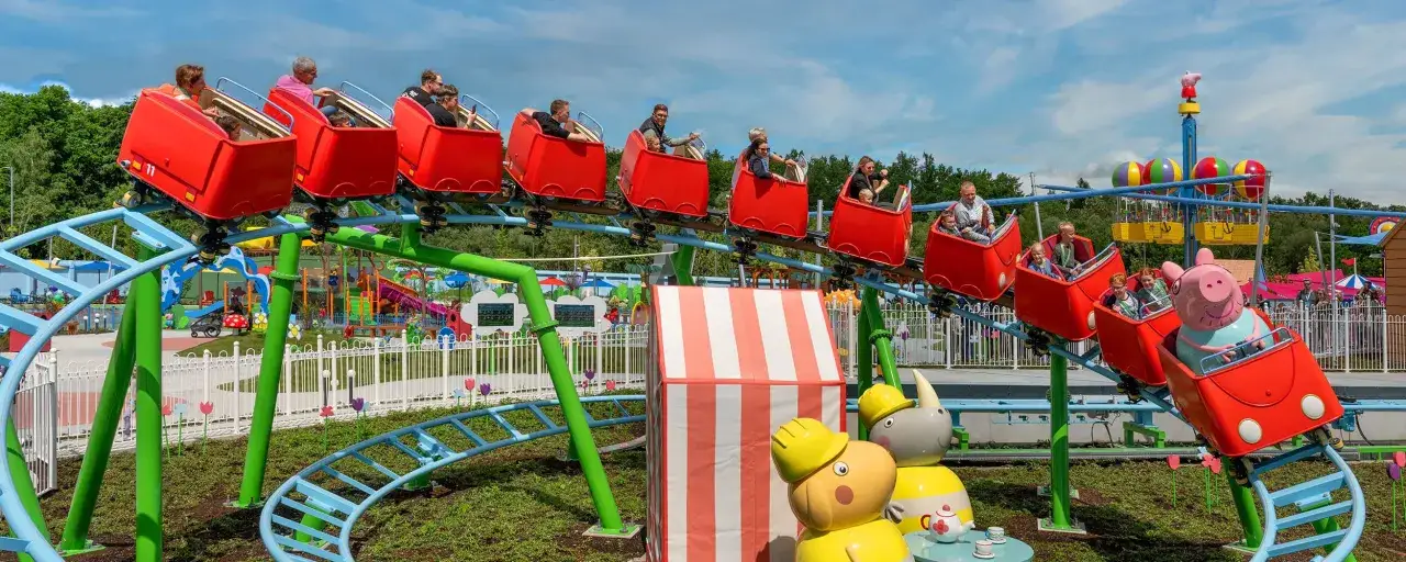Familien genie&szlig;en eine Fahrt auf der Achterbahn im Legoland Peppa Pig Land.