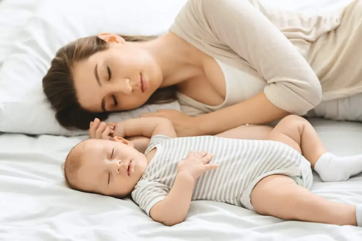Mama śpi obok swojego dziecka, kołysanka dla dziecka ukołysała ich oboje do snu.