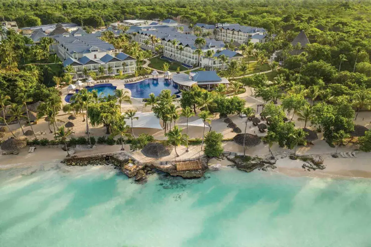 Rajski widok na Viva Dominicus Beach by Wyndham. Luksusowy resort z basenami, palmami i piaszczystą plażą nad turkusowym morzem.
