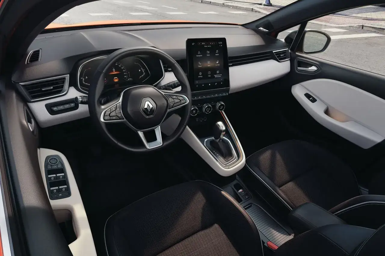 Wnętrze Renault Clio 2025: nowoczesny kokpit z dużym ekranem dotykowym, cyfrowymi zegarami i eleganckimi detalami.