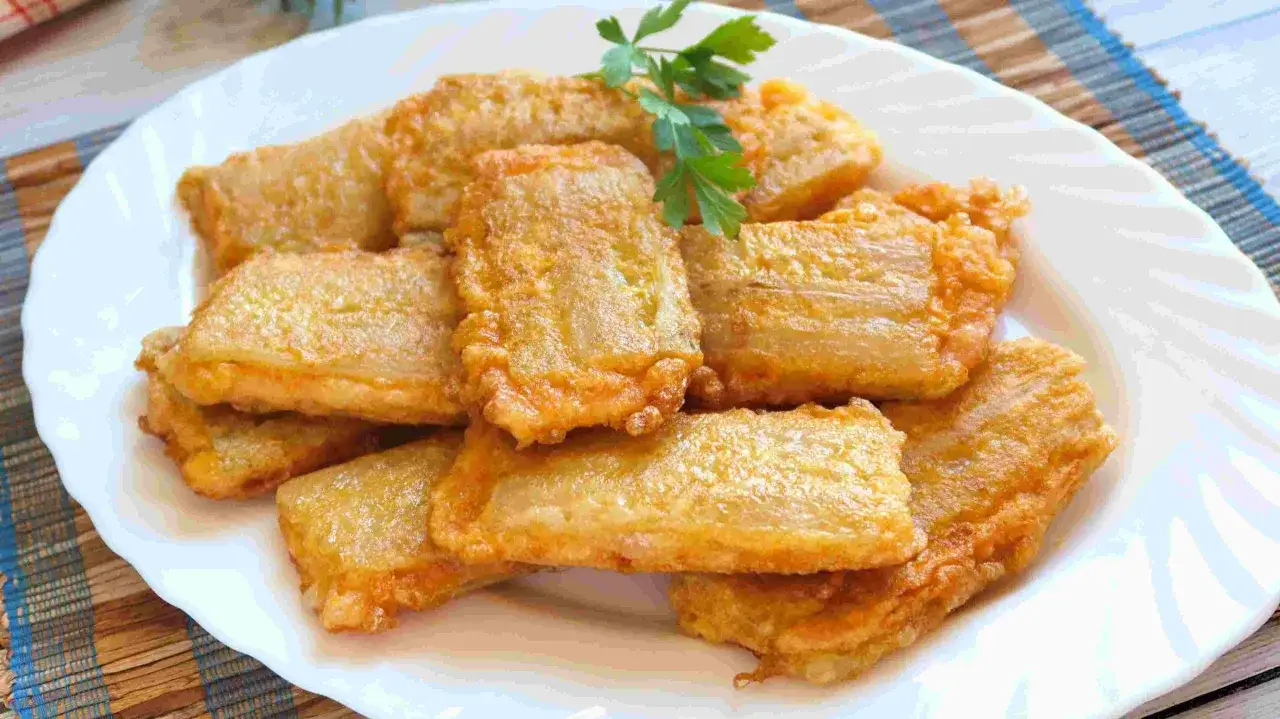 Pancakes dorados y crujientes, unas deliciosas pencas rellenas, servidas en un plato blanco con una ramita de perejil.