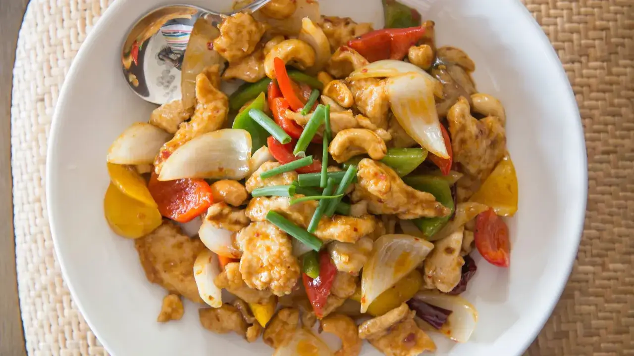 Un plat color&eacute; de poulet aux noix de cajou, poivrons, oignons et ciboule. Un d&eacute;lice croustillant et savoureux.