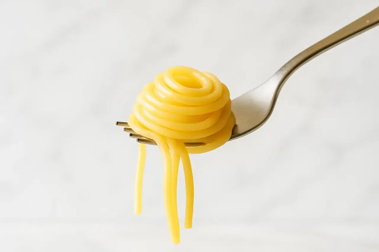 Spaghetti arrotolati su una forchetta, un piatto che può avere un indice glicemico variabile a seconda della cottura.