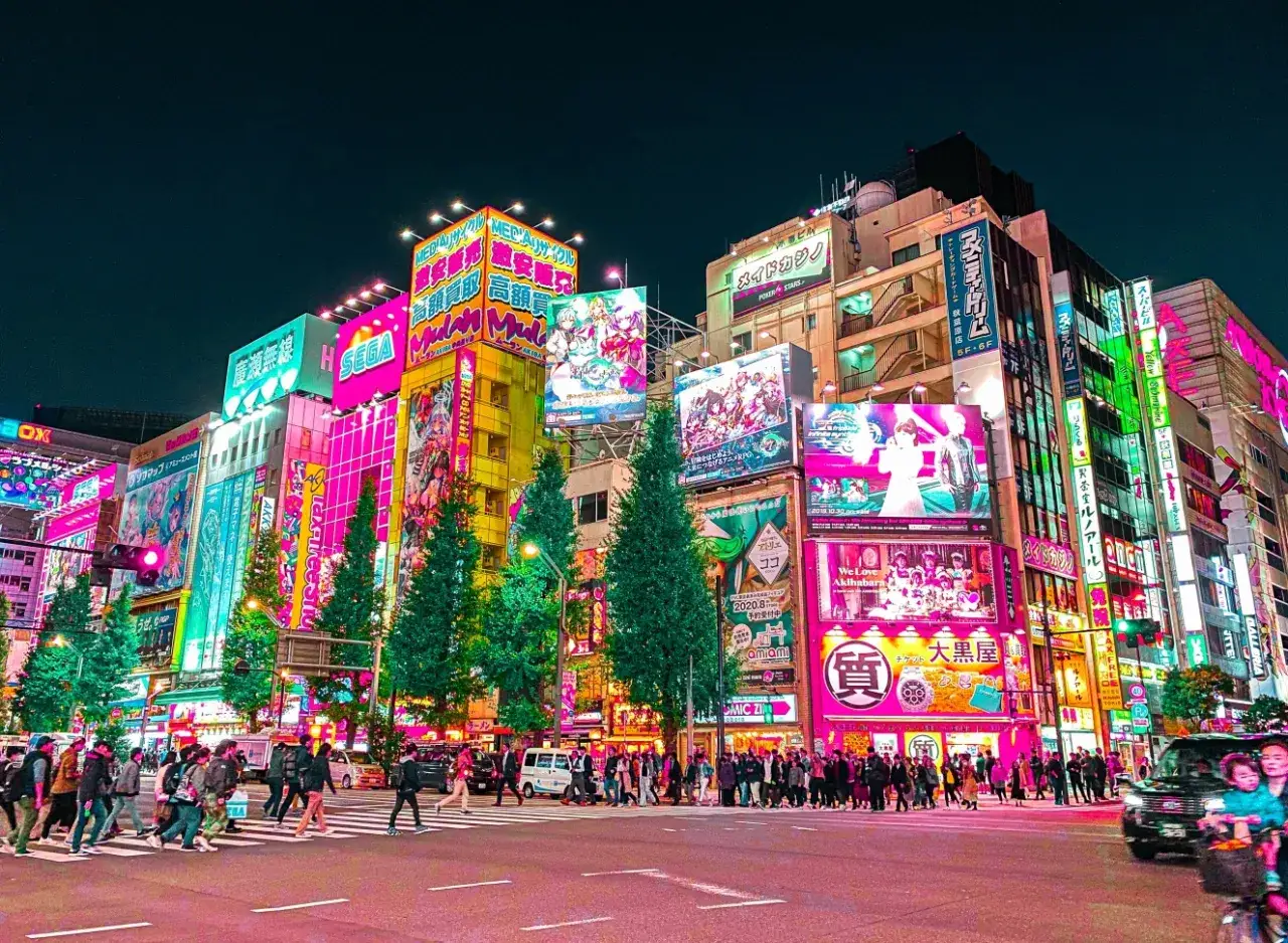 Neonowe budynki Akihabary nocą, pełne reklam anime i gier. To miejsce, co warto zobaczyć w Tokio, tętni życiem i kolorami.