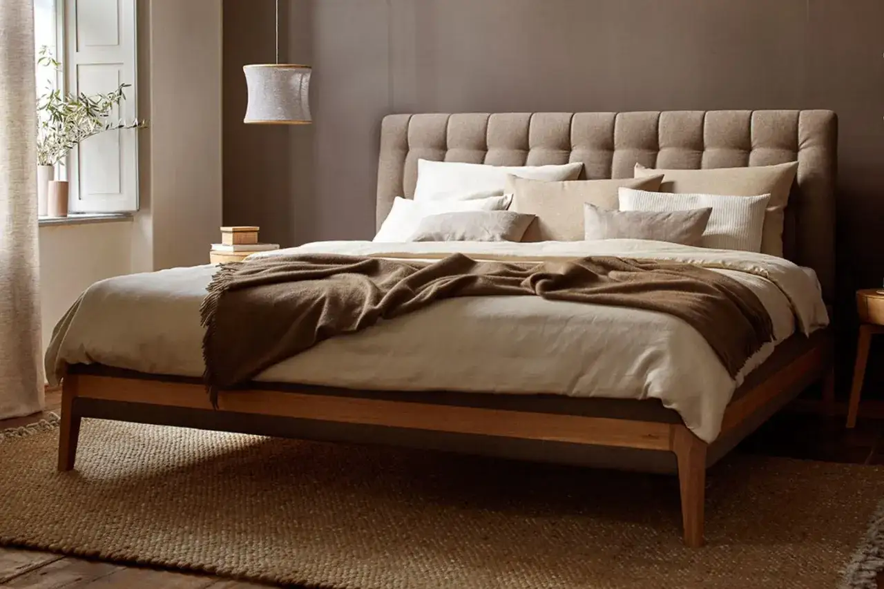 Gemütliches Schlafzimmer: Einladendes bett einrichten mit vielen Kissen und einer warmen Decke. Natürliche Farben und Materialien schaffen eine Oase der Ruhe.