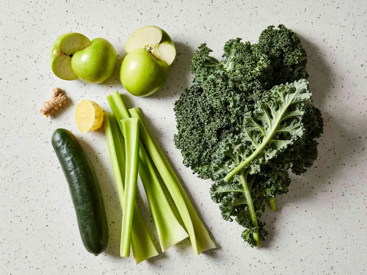 Zutaten für ein erfrischendes green juice rezept: Grünkohl, Äpfel, Gurke, Sellerie, Zitrone und Ingwer.
