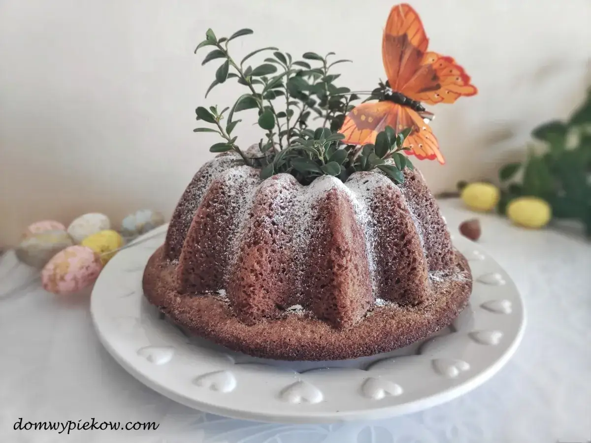 Pyszna babka orzechowa, ozdobiona zielenią i motylem, czeka na wielkanocne świętowanie.