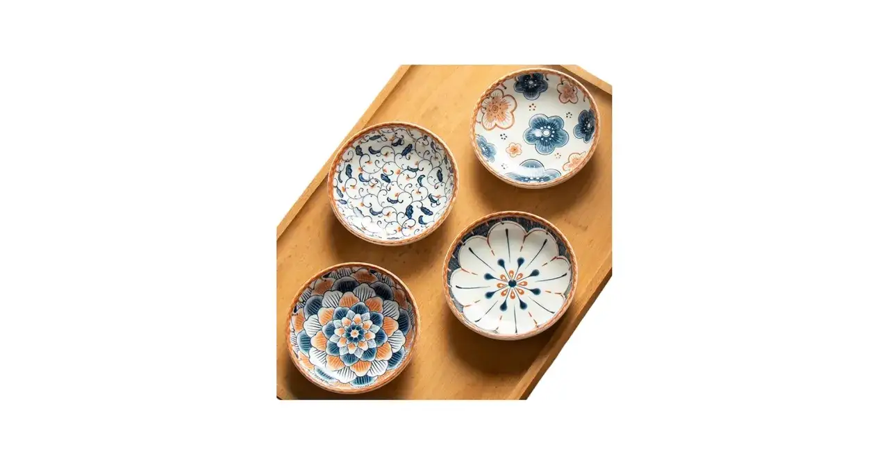 Four decorative ceramic dishes, perfect for serving Japanese dipping sauces, feature floral and vine patterns in blue and orange.