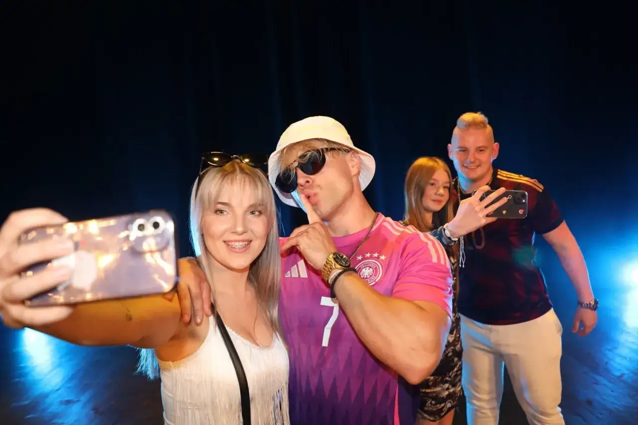 Fani robią sobie selfie z artystą podczas jego **skolim trasa koncertowa**.