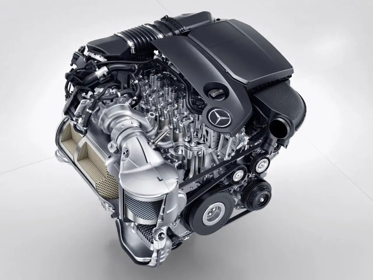 Silnik OM651 z turbosprężarką i widocznymi elementami układu dolotowego i wydechowego, z logo Mercedes-Benz.