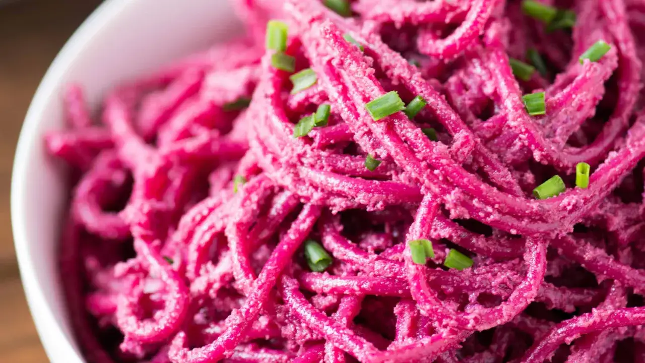 Spaghetti mit cremigem Rote Bete Pesto, garniert mit frischem Schnittlauch. Ein farbenfrohes und gesundes Gericht.
