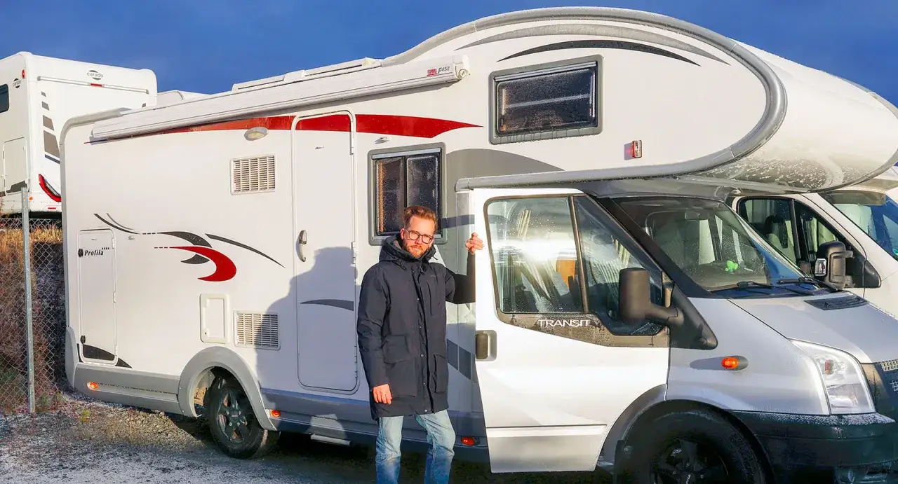 Man vid husbilen, kanske ett chausson problem? Sn&ouml; p&aring; taket och en kall dag.