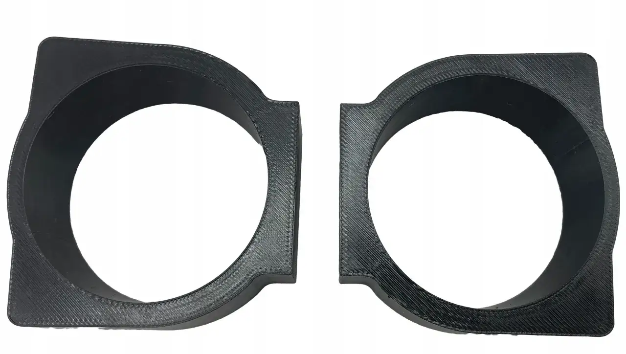Dwa czarne uchwyty na kubki do Opel Astra H, wykonane metodą druku 3D, z widoczną fakturą.