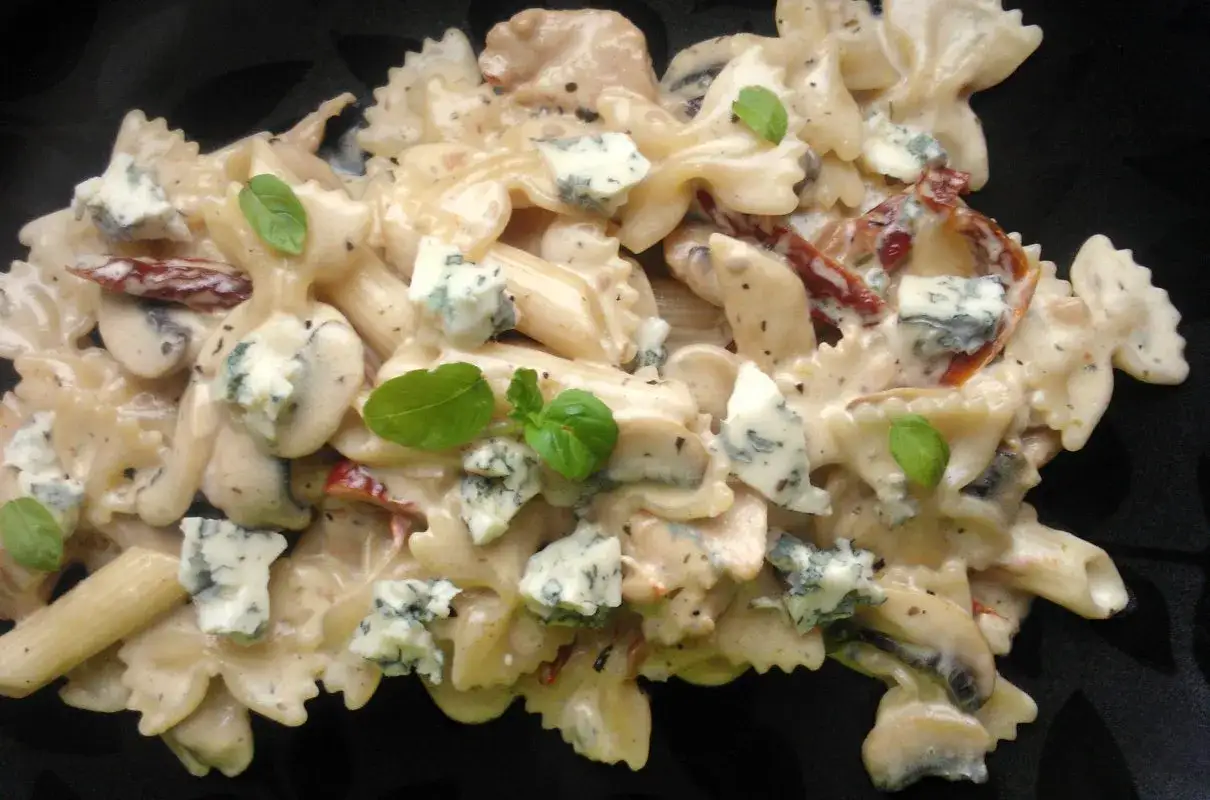 Pyszne dania z makaronem na obiad: farfalle i penne w kremowym sosie z gorgonzolą, suszonymi pomidorami i bazylią.
