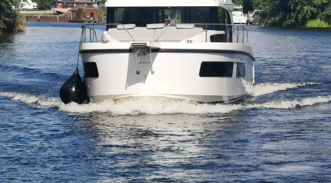 Ein weißes Motorboot gleitet mit guter **Boot Geschwindigkeit** über das Wasser und hinterlässt eine breite Bugwelle.