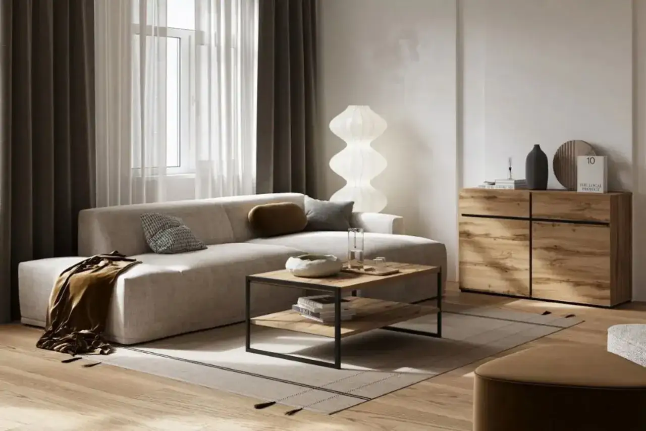 Beżowy salon inspiracje: nowoczesna sofa, stolik kawowy z drewna i metalu, komoda z szufladami, designerska lampa i zasłony.