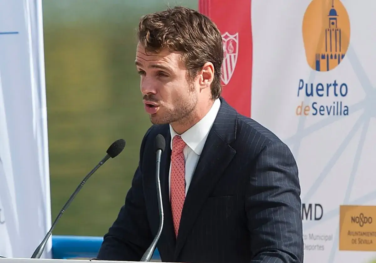 Jos&eacute; Mar&iacute;a Gonz&aacute;lez de Caldas, con traje y corbata, habla en un atril con micr&oacute;fonos. Fondo con logo de Puerto de Sevilla.