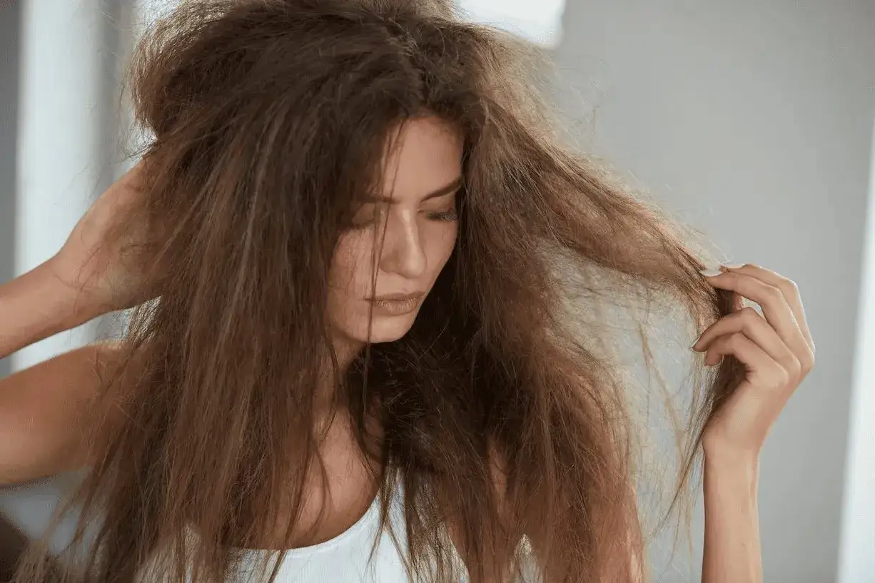 Mujer con pelo seco y enredado, como un estropajo. Busca remedios caseros para hidratarlo y darle brillo.