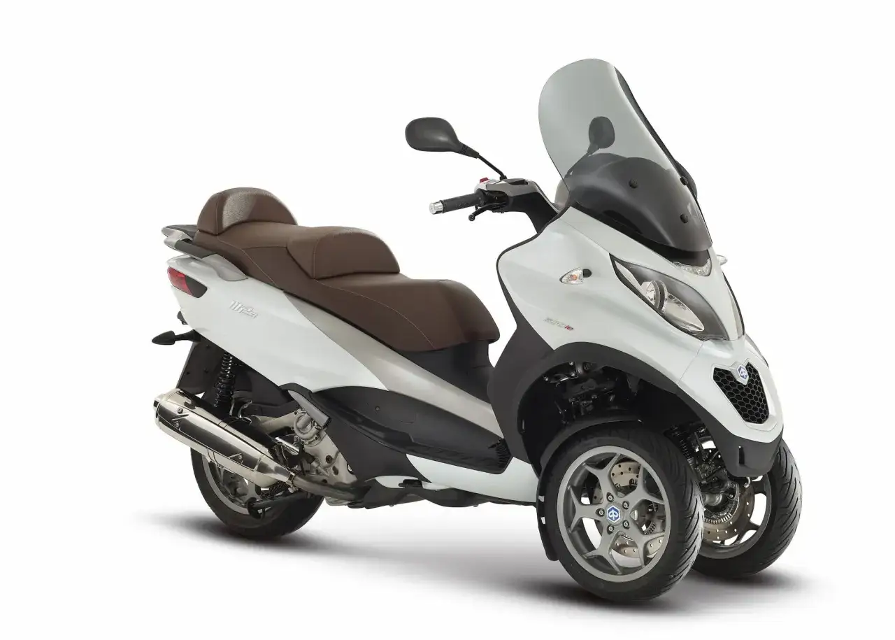 Scooter tres ruedas 2015 blanco con asiento marrón y parabrisas alto.