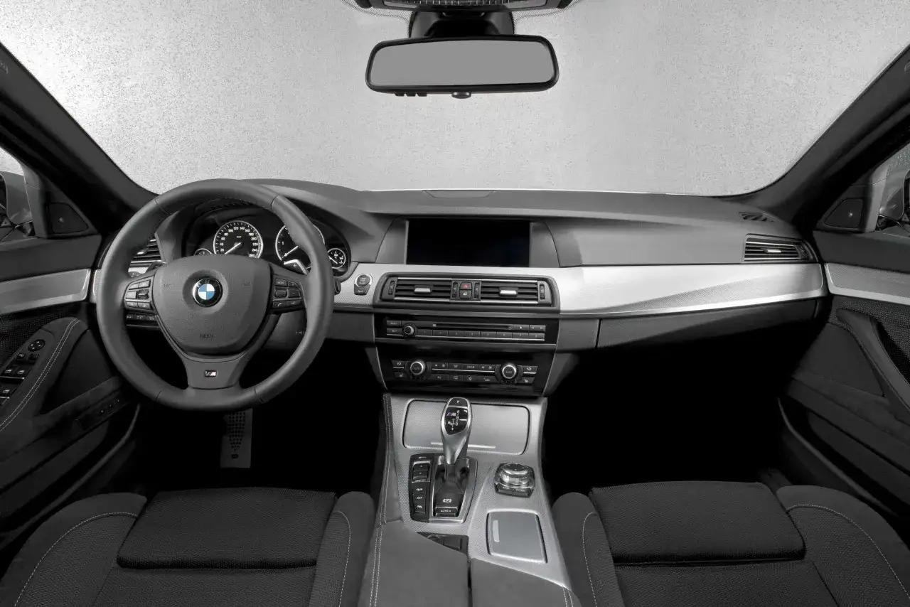 Wnętrze BMW 550d z czarną tapicerką, kierownicą M i nowoczesnym panelem środkowym.