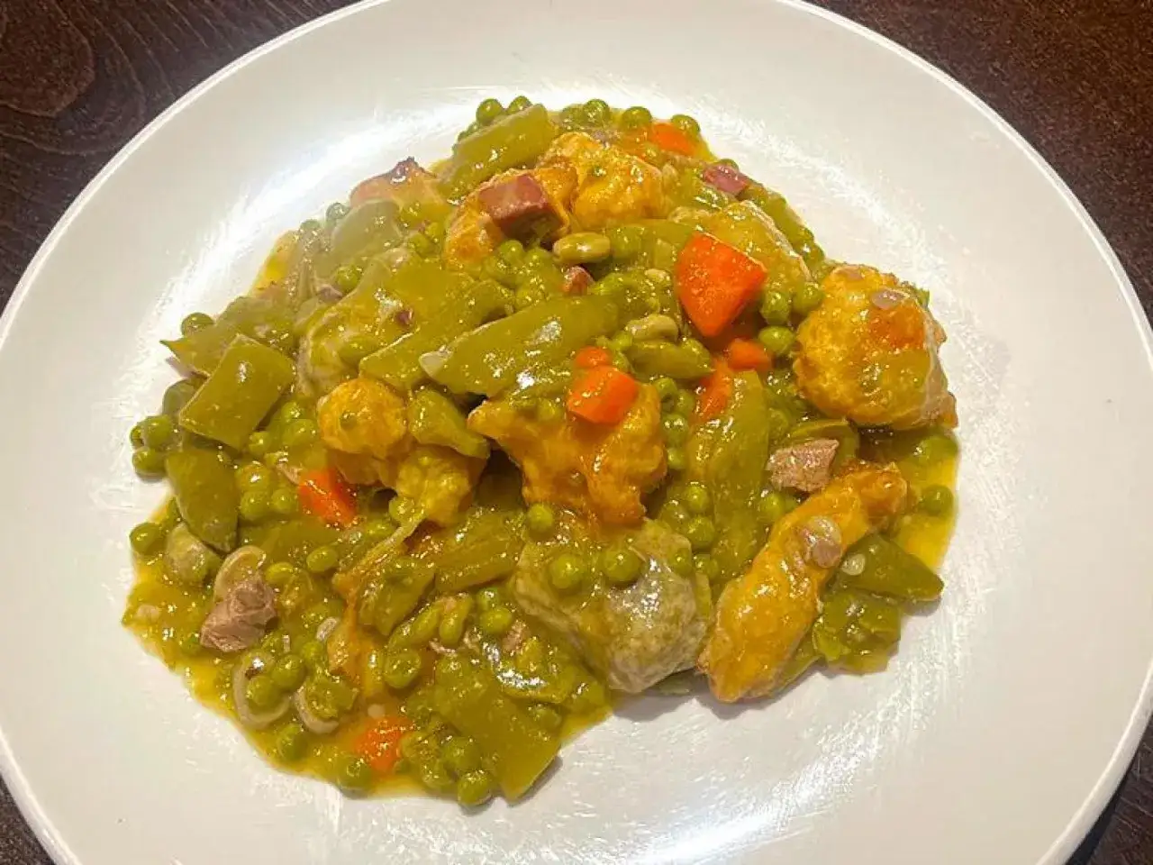 Guiso de judías verdes, guisantes y trozos de carne, un plato que evoca la comida típica de Palencia.