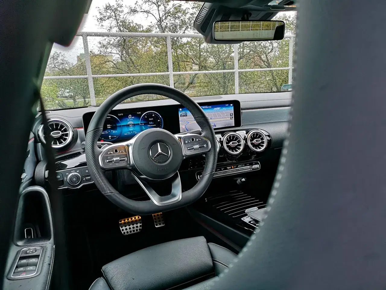 Wnętrze Mercedesa CLA: kierownica, cyfrowe zegary i nawigacja. Widok z perspektywy kierowcy.