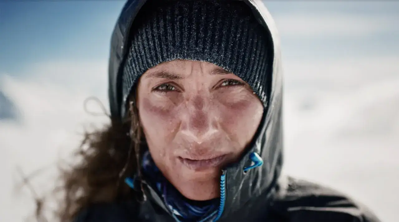 Krystle Wright, con il viso segnato dal freddo e dalla fatica, guarda dritto nell'obiettivo, pronta per la prossima avventura.