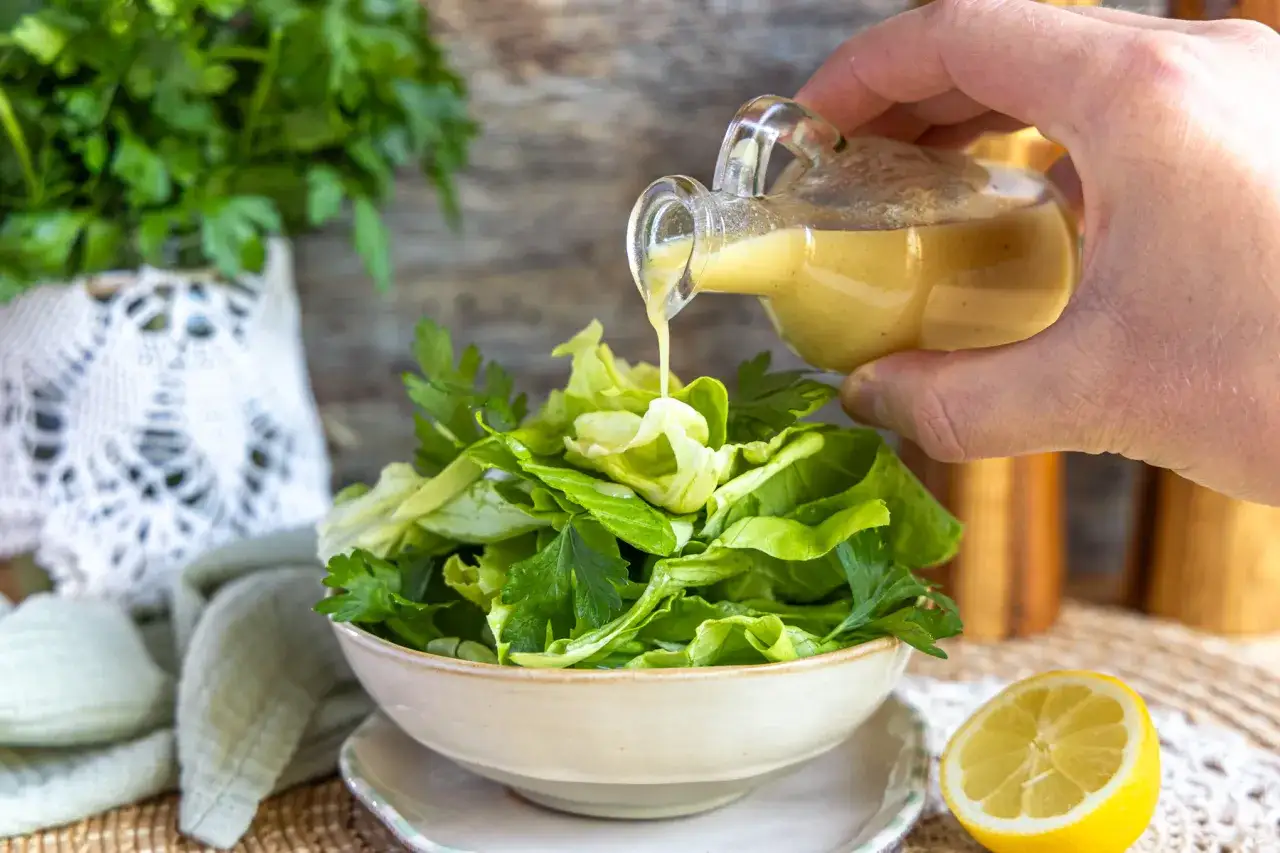 Frischer Salat wird mit Dressing &uuml;bergossen. Perfekt f&uuml;r salate zum vorbereiten am vortag, damit sie schnell servierfertig sind.