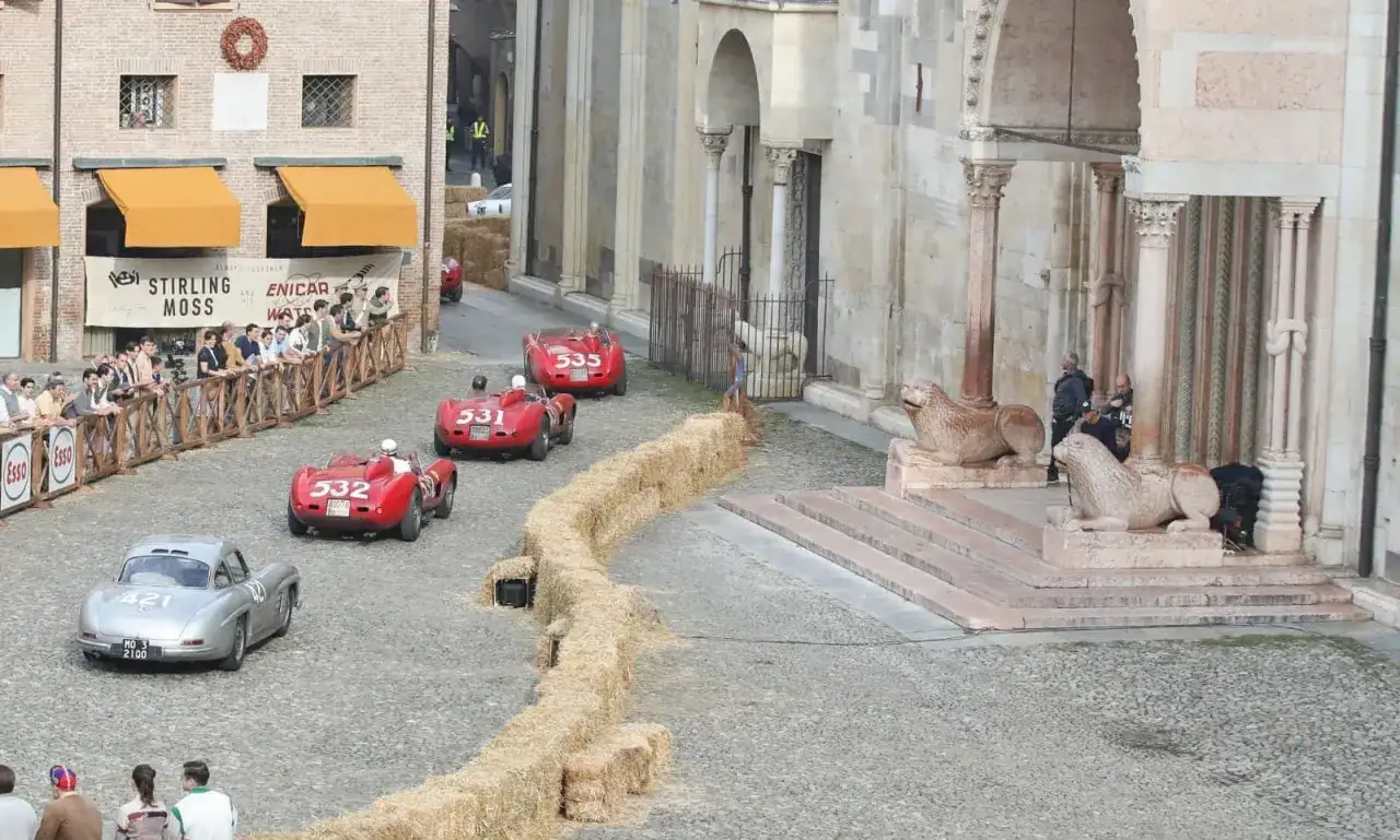 Wyścig klasycznych Ferrari, jak z filmu. Widzowie oglądają zmagania na brukowanej ulicy, a słomiane bele wyznaczają trasę.