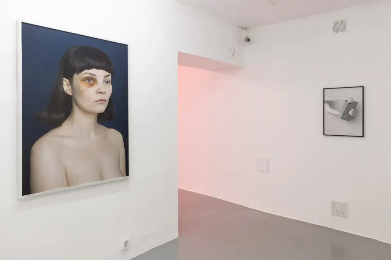 Portret Marty Zgierskiej z widocznym siniakiem na oku. Obok, w galerii, czarno-białe zdjęcie dłoni trzymających cegłę.