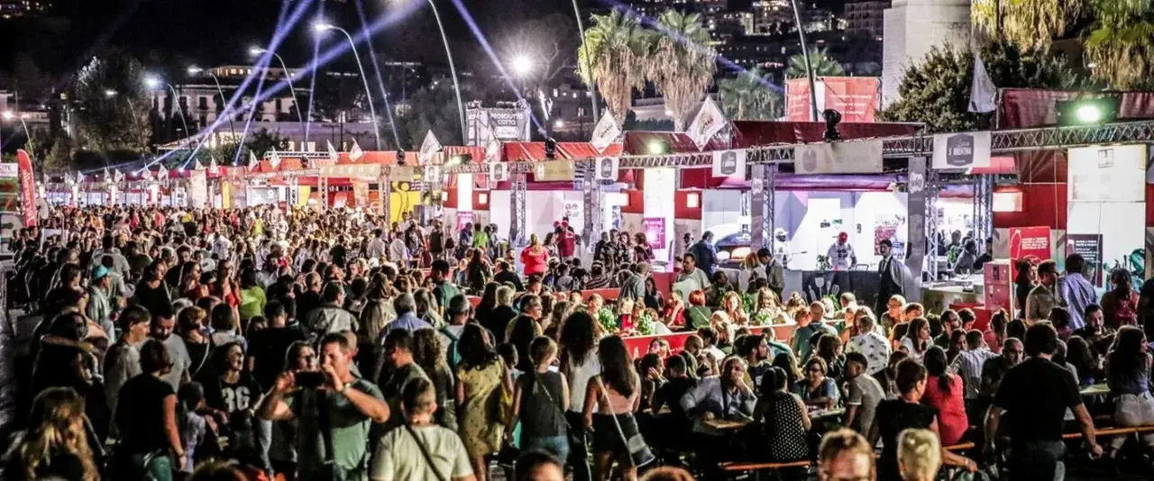 Menschenmassen genie&szlig;en ein lebhaftes Pizza Festival in Berlin. St&auml;nde mit leckerem Essen, Musik und Lichtern schaffen eine festliche Atmosph&auml;re.
