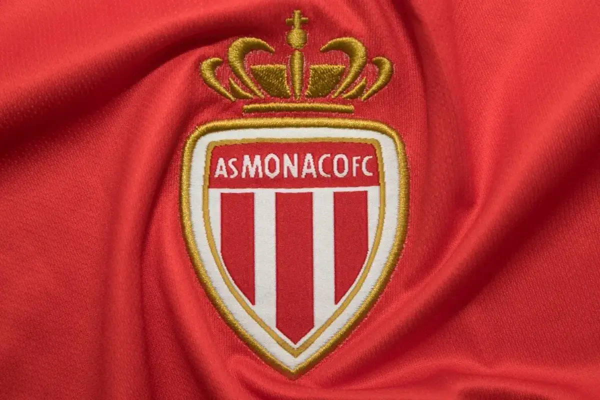 Herb AS Monaco FC na czerwonym tle.