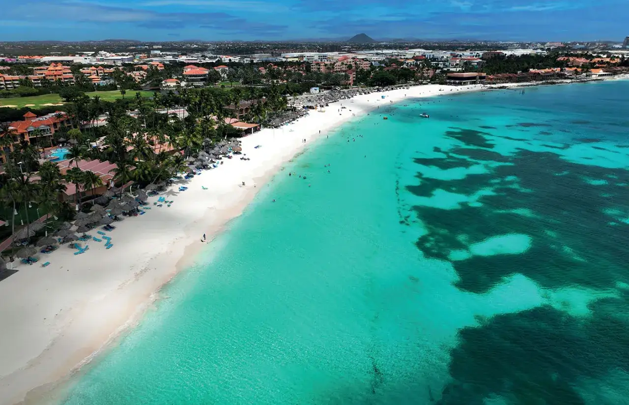 Rajskie plaże i turkusowe morze na aruba wakacje. Luksusowe hotele i palmy tworzą idealne tło dla wypoczynku.
