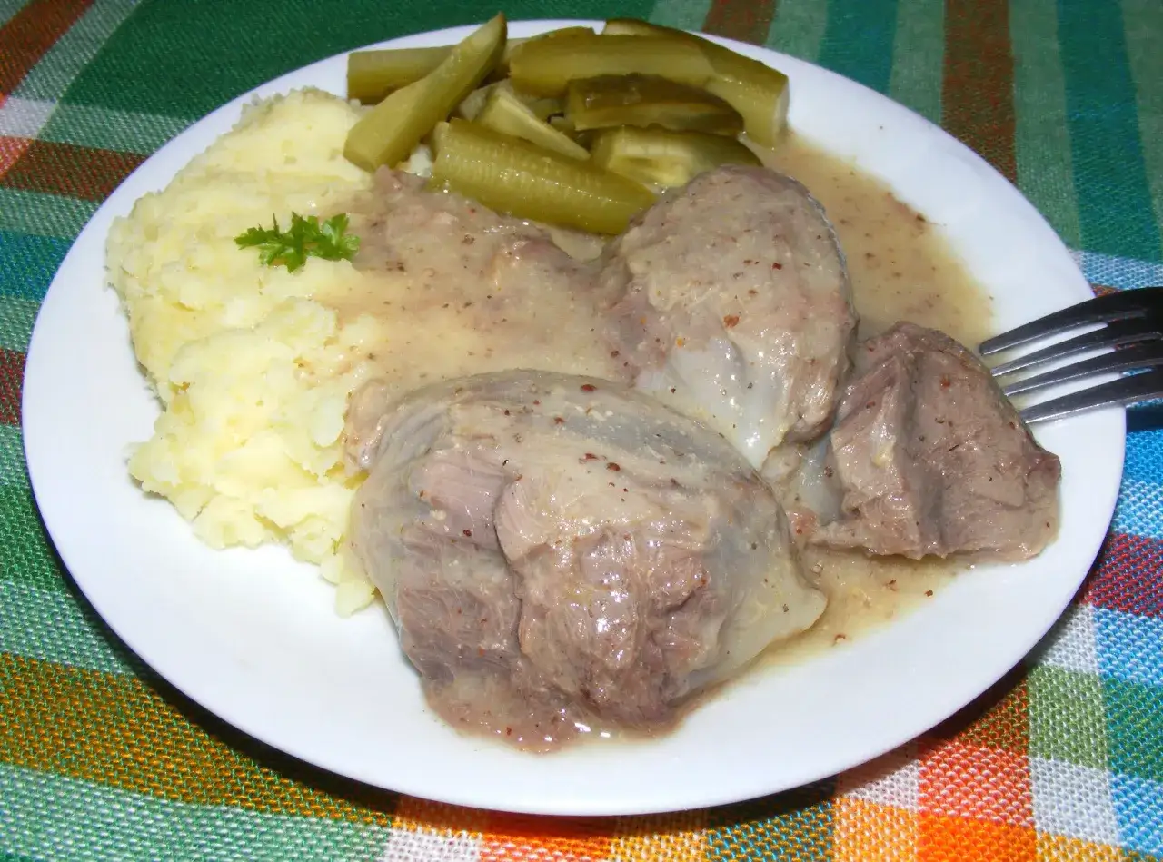 Na talerzu puree ziemniaczane, polane sosem żołądki z indyka i ogórki kiszone.