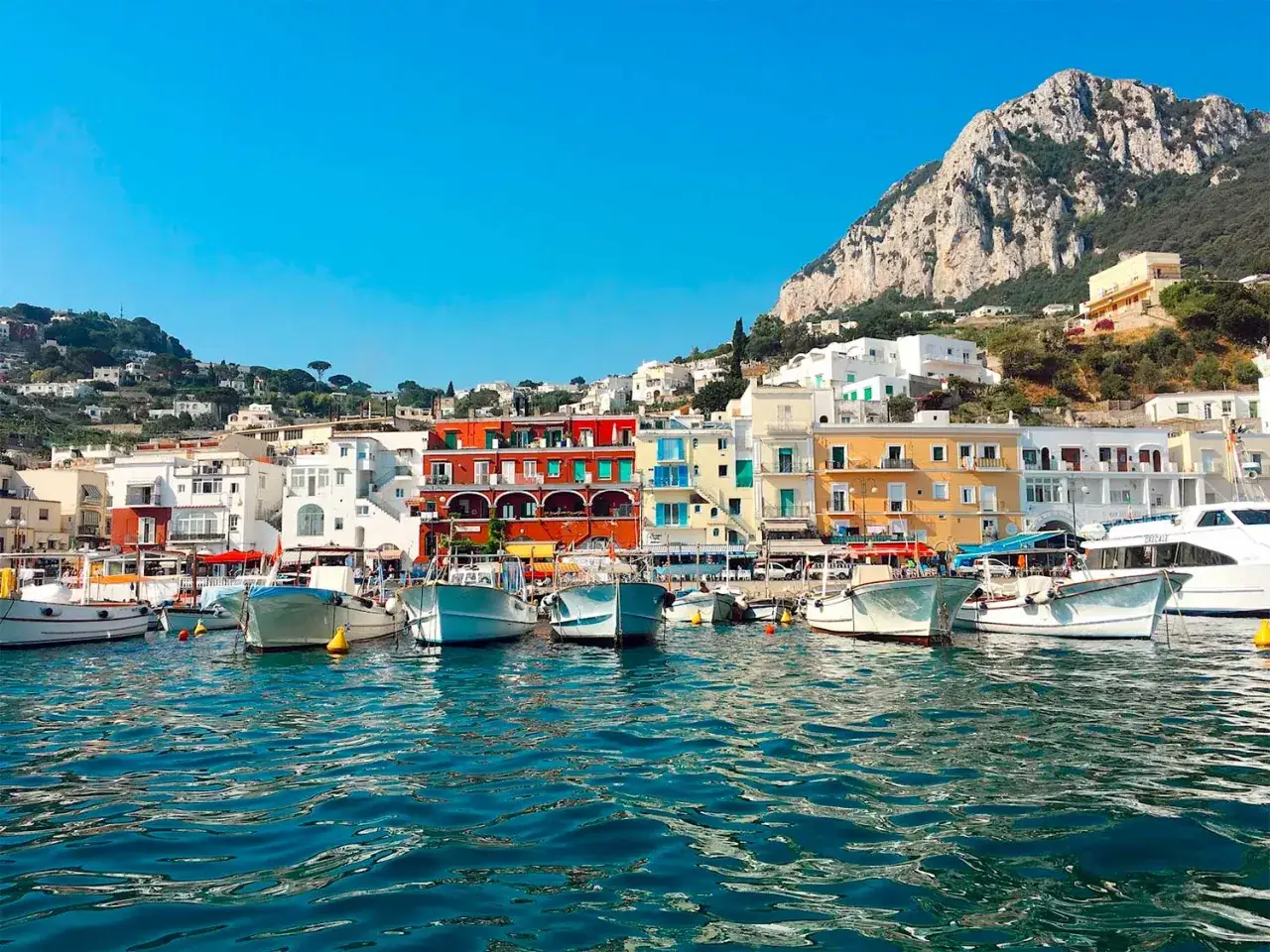 Vue du port de Capri, avec ses maisons colorées et son imposante montagne. Un rêve d'évasion, entre Ischia ou Capri.