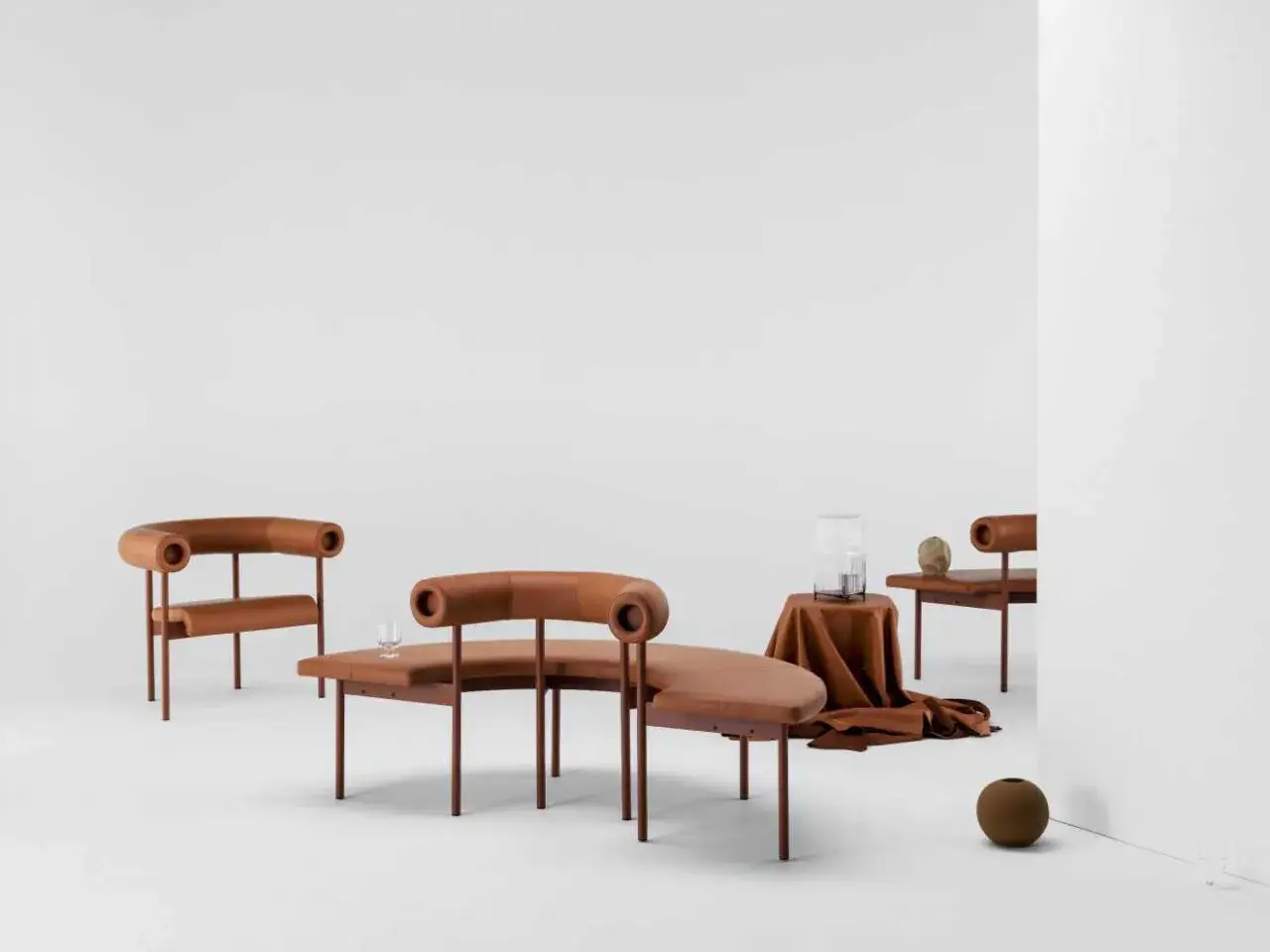 M&ouml;bler i l&auml;der och metall, inspirerade av Matti Klenells design. En soffa och tv&aring; f&aring;t&ouml;ljer i en varmbrun nyans.