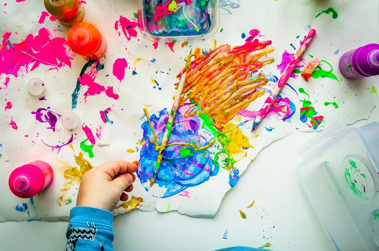 Manos pequeñas creando arte para niños de 3 a 5 años. Pinturas de colores vibrantes y pinceles listos para la diversión creativa.