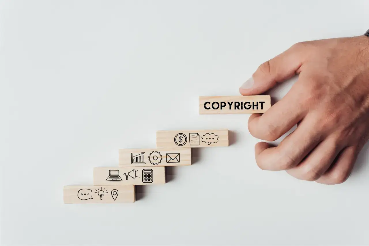 Drewniane klocki symbolizujące rozwój biznesu, z napisem COPYRIGHT. To właśnie takie zdjęcia stockowe co to, czyli wizualizacje koncepcji.