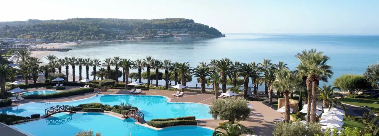 Traumhafter Blick auf das Meer und den Poolbereich eines Resorts, wie aus einem M&auml;rchen der TUI Blue Lagoon Princess. Palmen s&auml;umen den Weg.