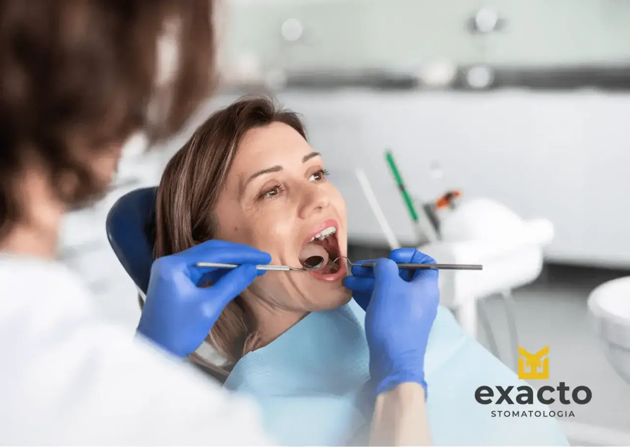 Kobieta w ciąży z bólem zęba u dentysty. Specjalista bada jej jamę ustną.