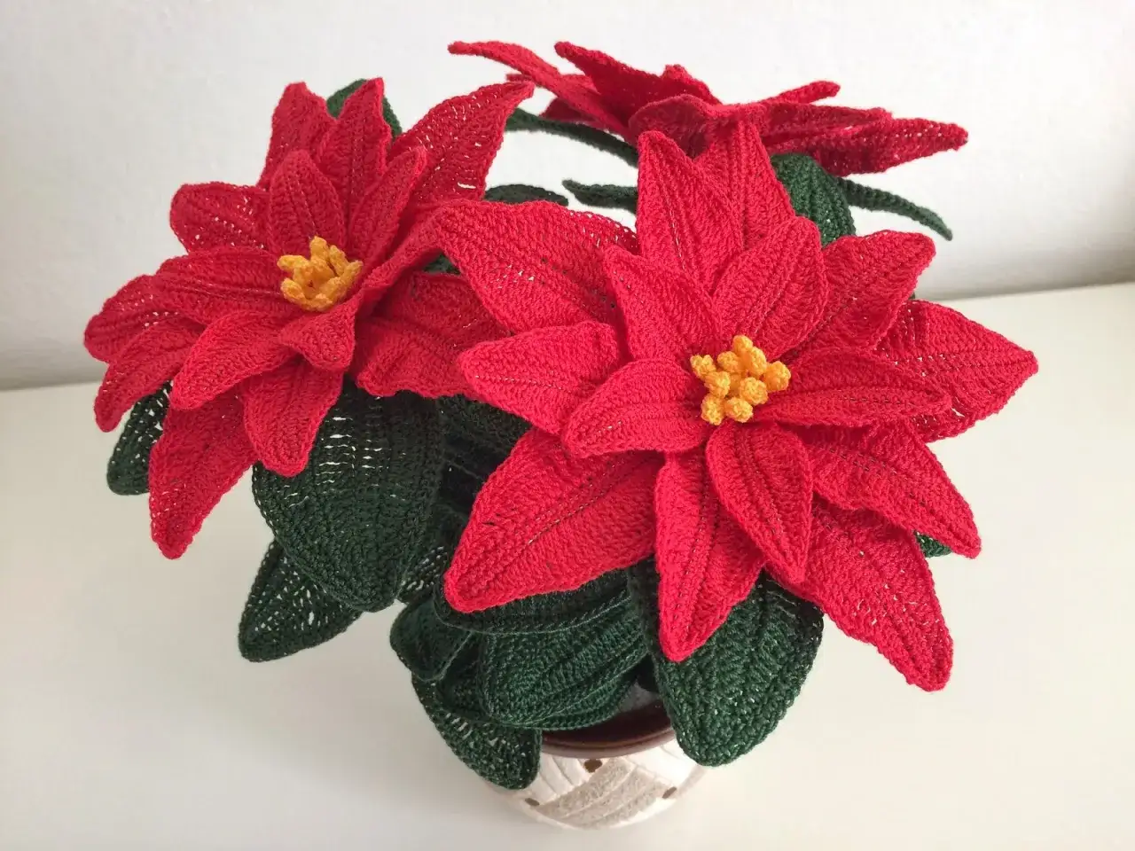 Stelle di Natale all'uncinetto con spiegazioni. Fiori rossi e foglie verdi, un'opera d'arte handmade.