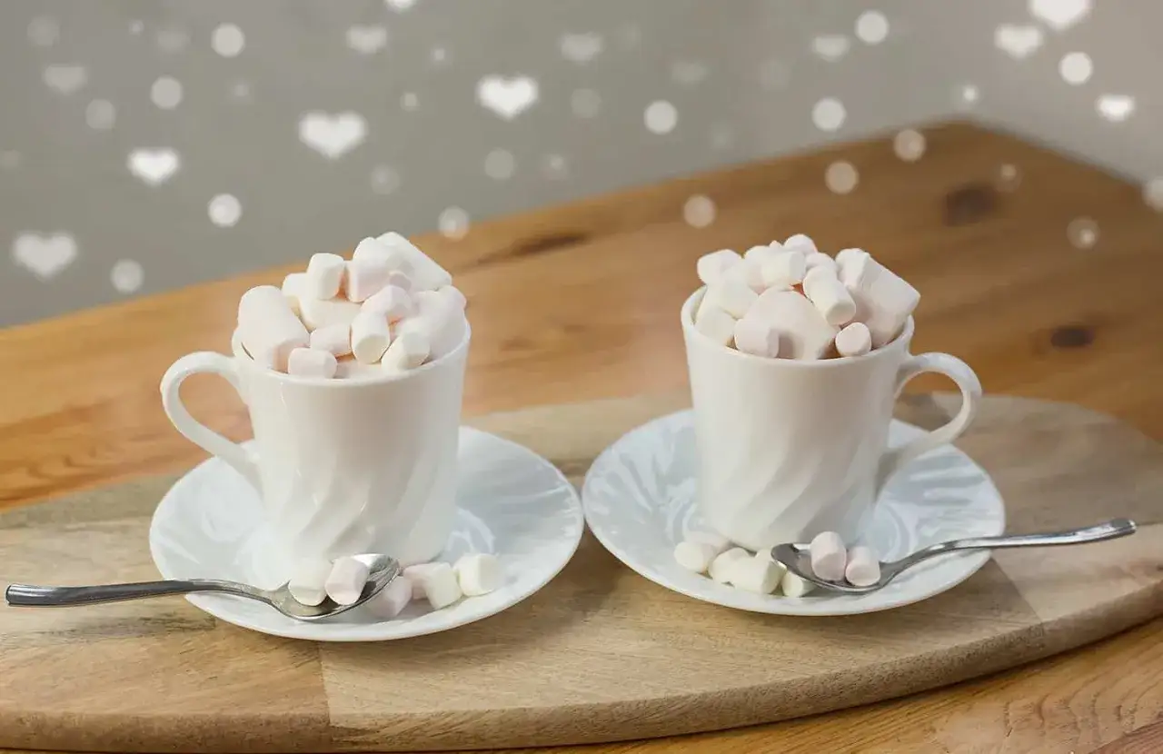 Dwa kubki pysznego espresso z mlekiem, ozdobione piankami. Idealne na walentynkowy wiecz&oacute;r.