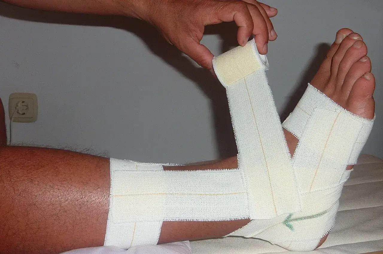 Aplicación de vendaje funcional en tobillo para soporte y recuperación.