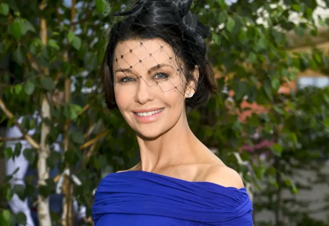 Anna Popek w niebieskiej sukni i stylowym fascynatorze. Jej wiek jest nieistotny, gdy patrzy się na jej promienny uśmiech.
